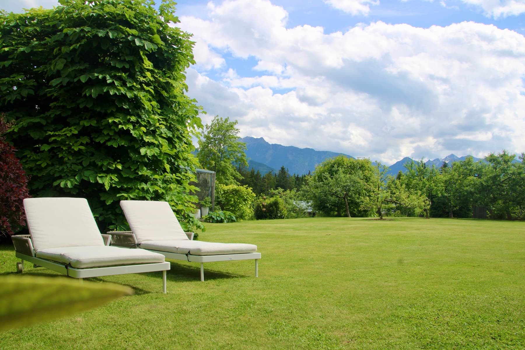 Garten mit Liegestühlen und Bergblick auf den Dachstein – Ferienwohnung Ramsau